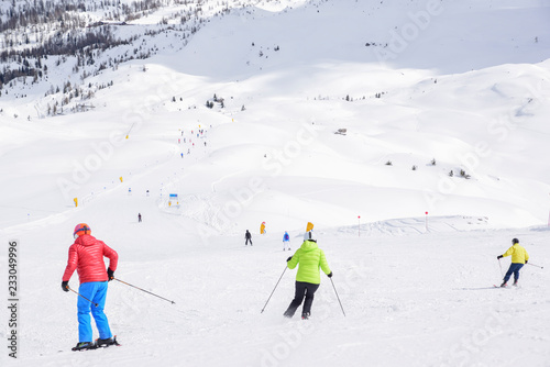 ski slope with skiers in the Alps