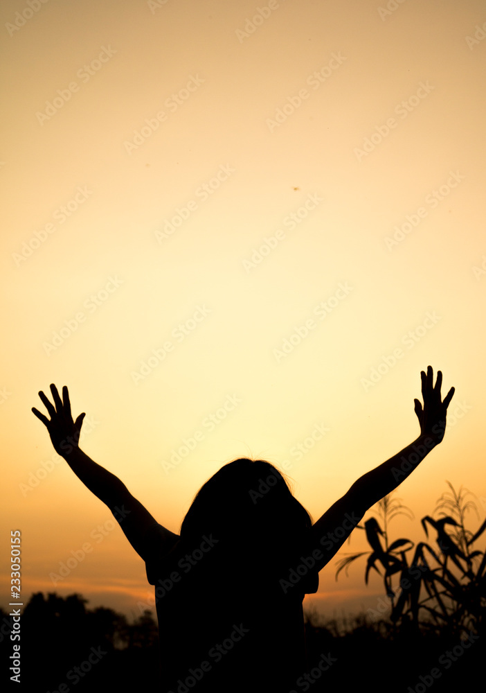 Girl lifting her hands up in the air across the field Girl lifting her hands up in the air across the field