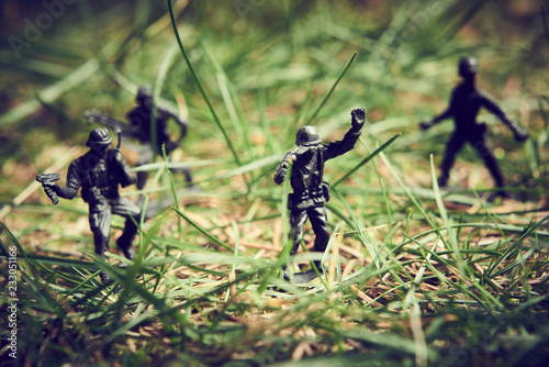 Soldiers in jungle fighting. Concept image of toy plastic soldiers in real grass. Selective focus.