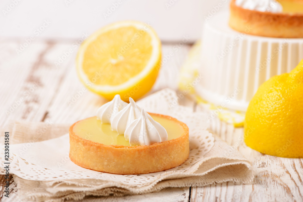 Lemon pie on the table with citrus fruits. Traditional french sweet pastry tart. Delicious, appetizing, homemade dessert with lemon curd cream. Copy space