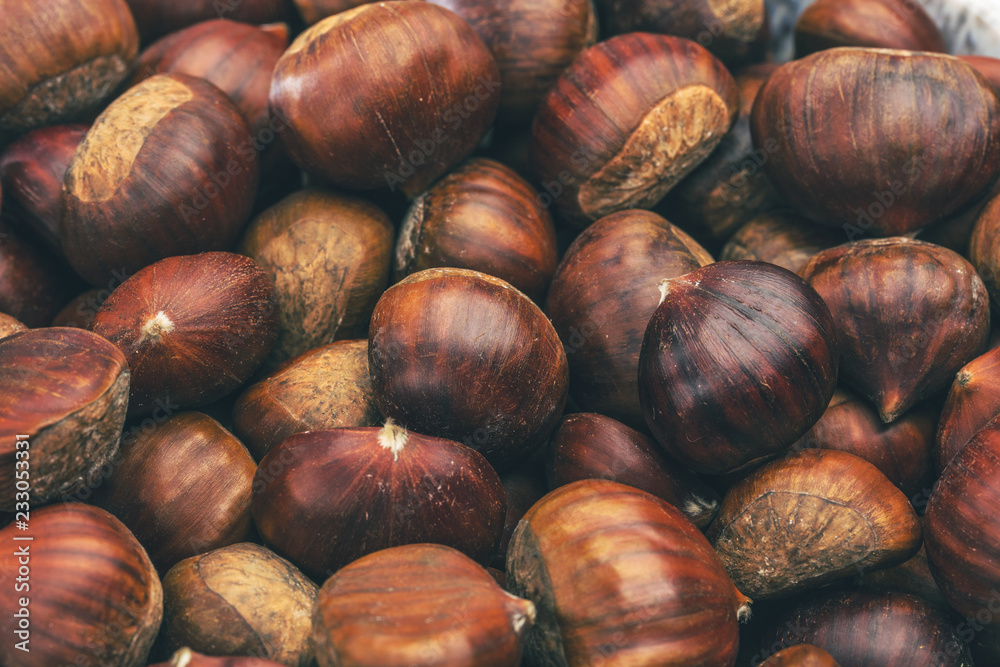 Obraz premium Roasted chestnuts served in chestnut pan on an old table