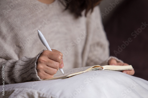 Mujer morena escribiendo a mano una carta photo