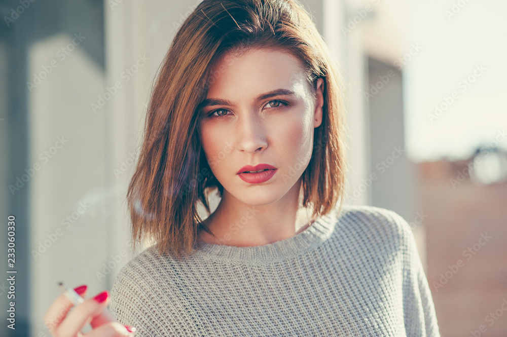 Pretty young girl smoking cigarette outside Stock Photo