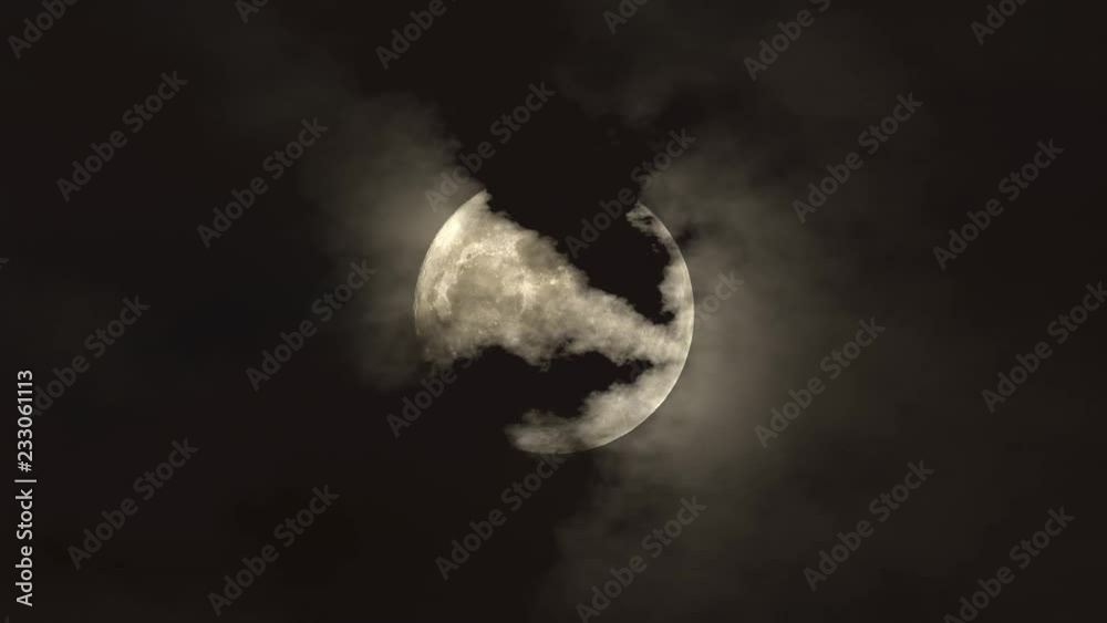 Clouds floating across the moon on a dark night