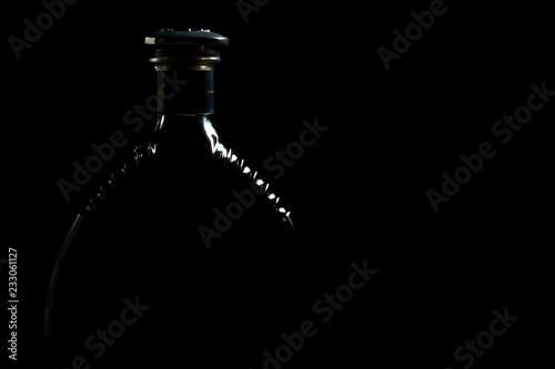 Silhouette Of Luxurious Alcohol Cognac Bottle Against Black Background