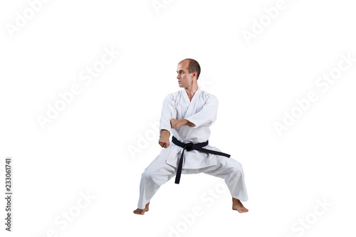 Adult active athlete trains formal karate exercises on white background