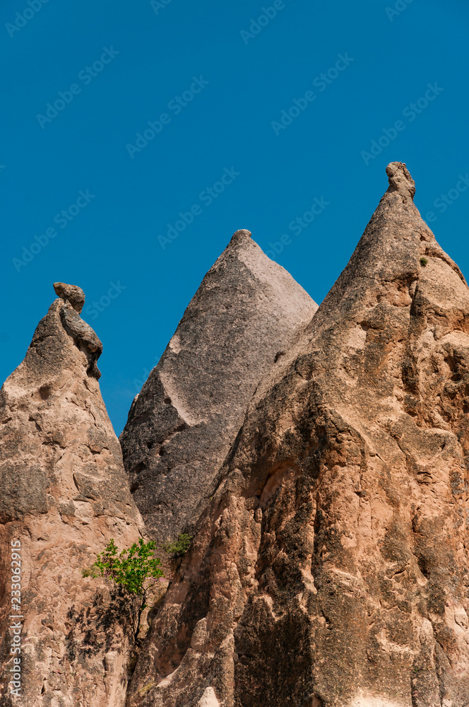 A detail from the structure of Cappadocia. Impressive fairy chimneys of sandstone in the canyon near Cavusin village, Cappadocia, Nevsehir Province in the Central Anatolia Region of Turkey. Clear sky.