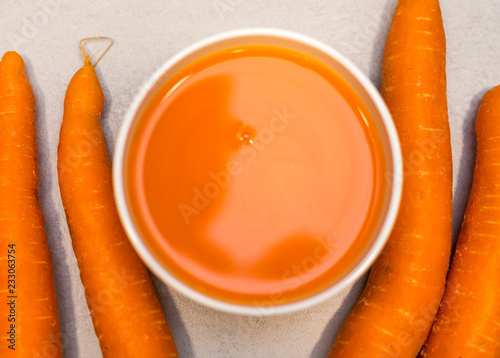 Carrots and fresh juice on the grey concrete table photo