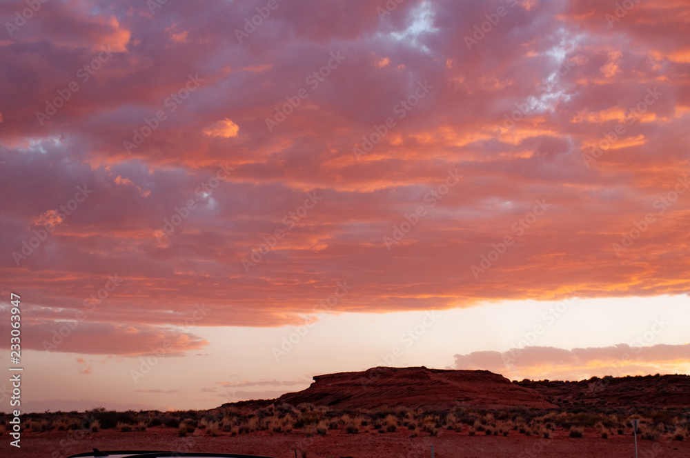 Clouds in a red colored sunset in the Colorado Desert Plateau at the Tuba City, United States. It is the spectacle of nature - the first hints of rose that creep into the sky and turn into a blaze