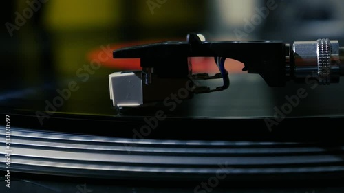 A needle is put down on the spinning black vinyl on the turntable slow motion photo