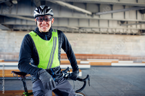 Image of man in protective helmet standing with bicycle