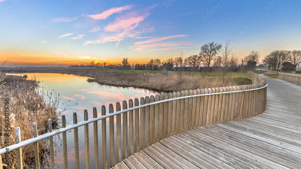 Plankied balustrade sunset over swamp