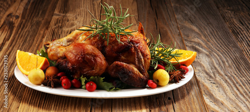 Baked turkey or chicken. The Christmas table is served with a turkey, decorated with fruits, salad and nuts. Fried chicken, table. Christmas dinner