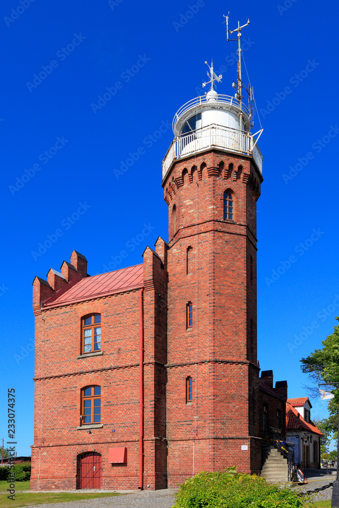 Obraz premium Ustka, Pomerania, Poland - Historic lighthouse building at the Baltic Sea shoreline and Slupia river in Ustka