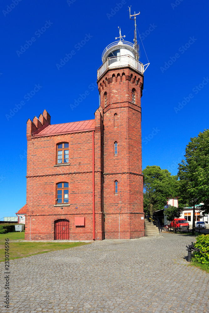 Obraz premium Ustka, Pomerania, Poland - Historic lighthouse building at the Baltic Sea shoreline and Slupia river in Ustka