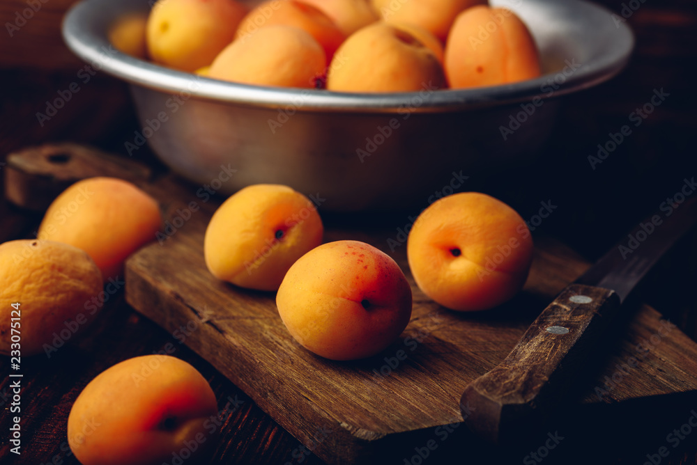 Mellow apricots with knife over cutting board Mellow apricots with knife over cutting board