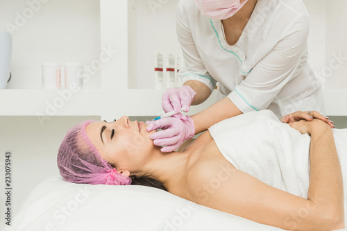 Young woman getting cosmetic injection in beauty clinic
