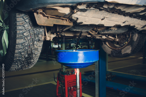 Service of trucks. Oil change in service center. waste oil drain system on a blurred truck background. photo