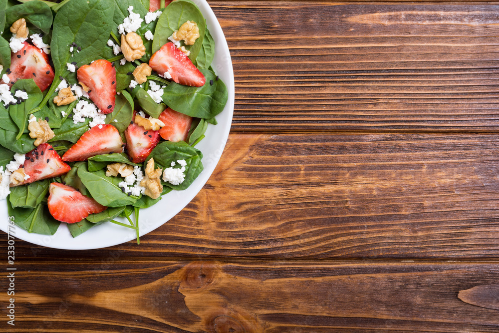 Strawberry salad with spinach , cheese and walnut . Healthy food