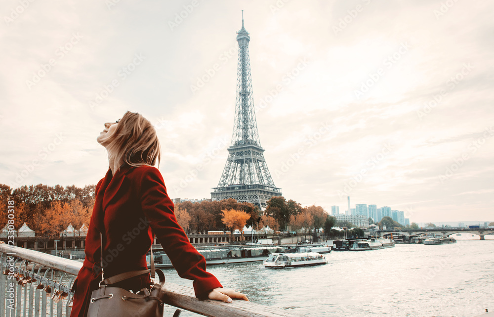 Style redhead girl in red coat and bag at parisian street with view at Eiffel tower in autumn season time - obrazy, fototapety, plakaty 