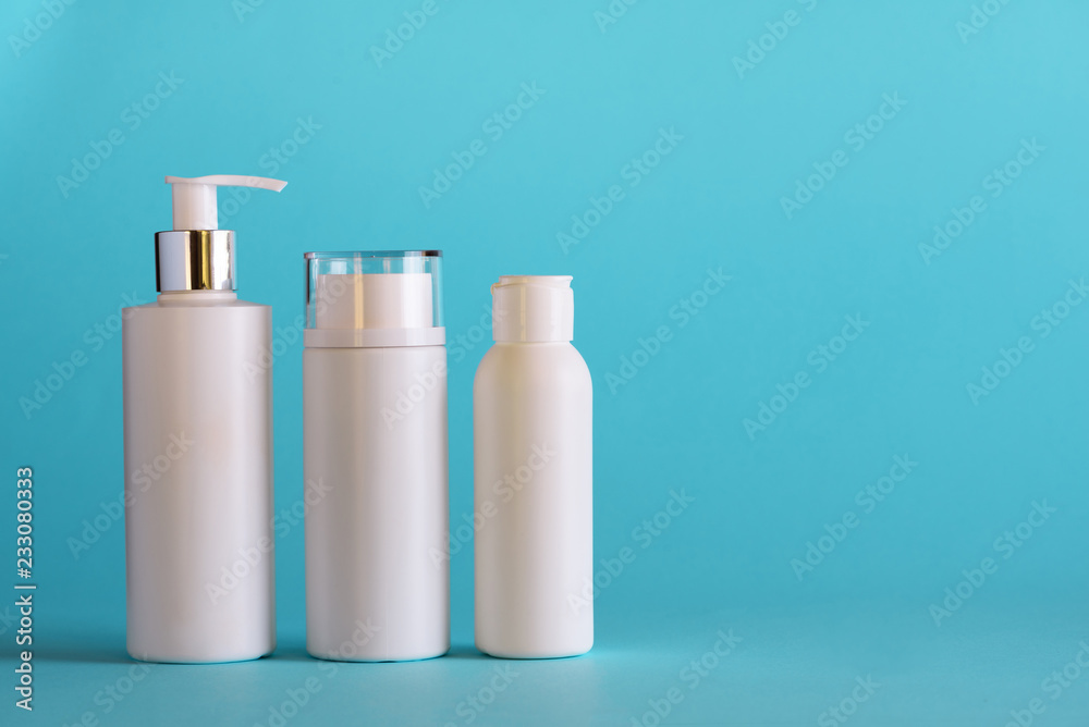 White cosmetic tubes on blue background with copy space. Skin care, body treatment, beauty concept. Banner White cosmetic tubes on blue background with copy space. Skin care, body treatment, beauty concept. Banner