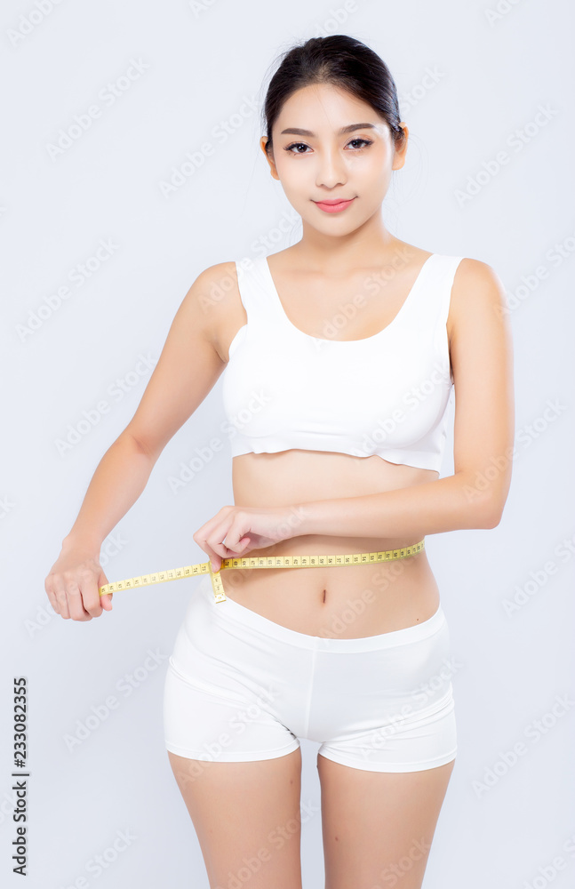 beautiful portrait asian woman diet and slim with measuring waist for weight isolated on white background, girl have cellulite and calories loss with tape measure, health and wellness concept. beautiful portrait asian woman diet and slim with measuring waist for weight isolated on white background, girl have cellulite and calories loss with tape measure, health and wellness concept.