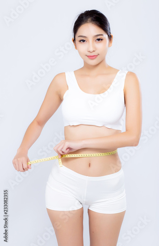 beautiful portrait asian woman diet and slim with measuring waist for weight isolated on white background, girl have cellulite and calories loss with tape measure, health and wellness concept. © N_studio