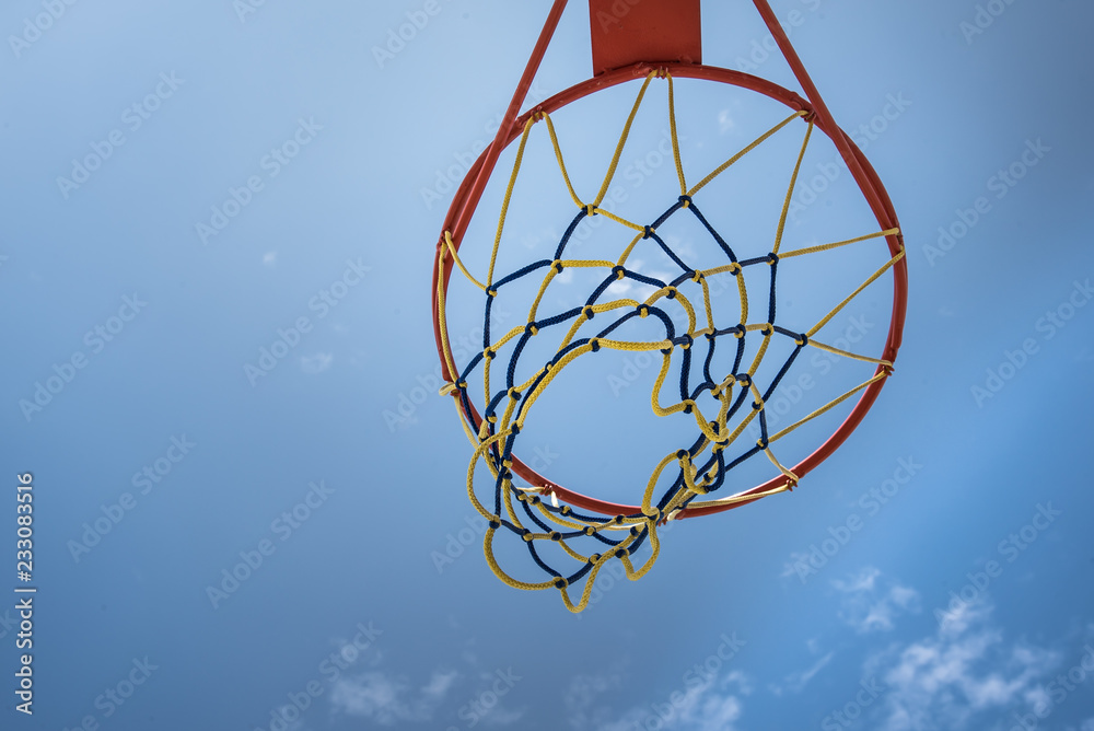 aro de basketball, ar de baloncesto, deporte hacia el cielo azul, con red multicolor