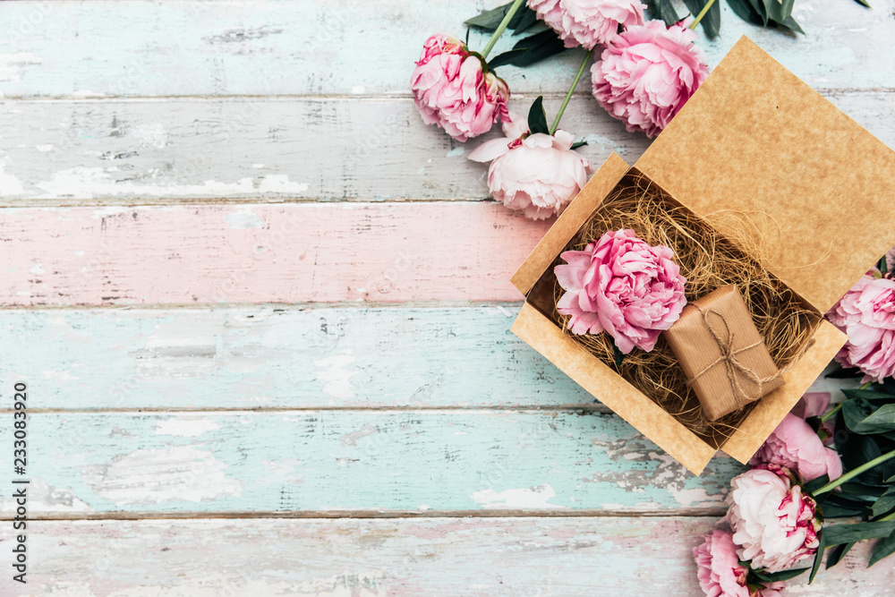 peonies and gift box on wooden table