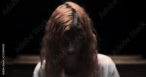 Scary girl obsessed by devil looking to the camera / exorcism concept