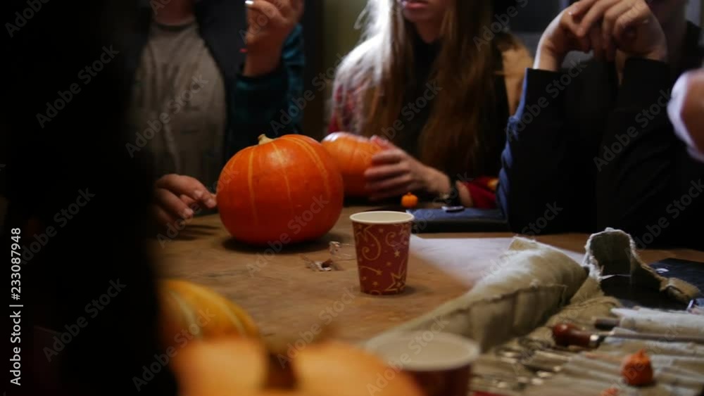 Halloween party. A group of people sitting and talking around the pumpkins Halloween party. A group of people sitting and talking around the pumpkins