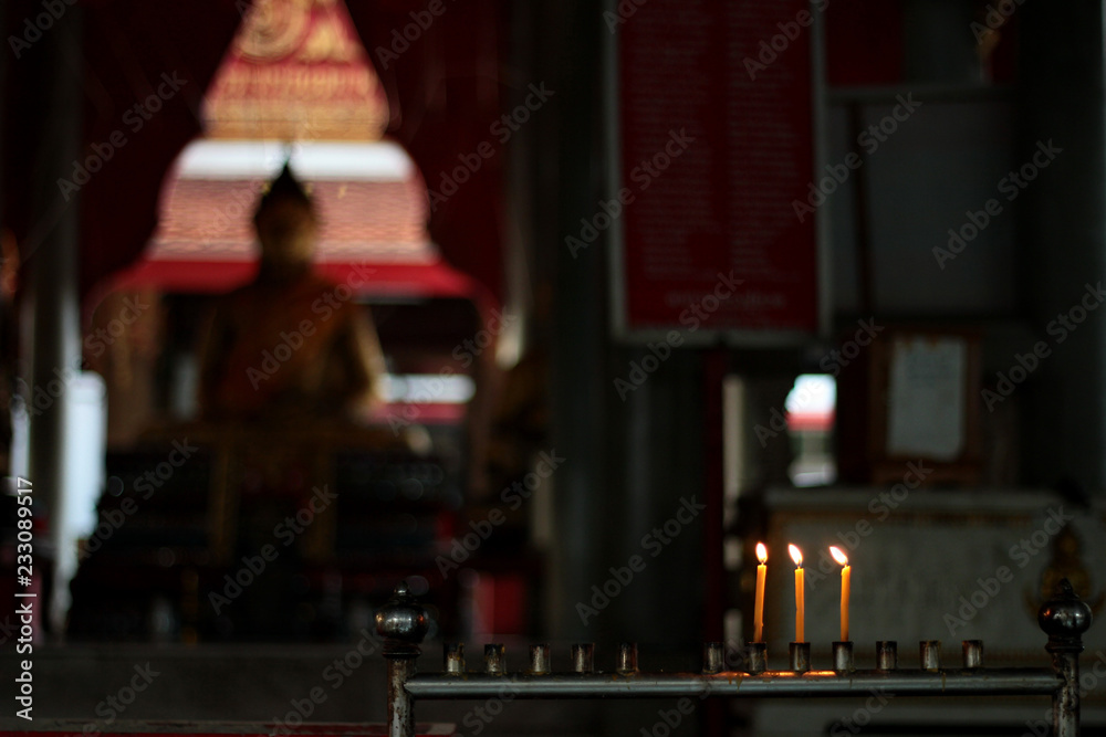 Lighted candle and incense for Buddha. Selective focus.