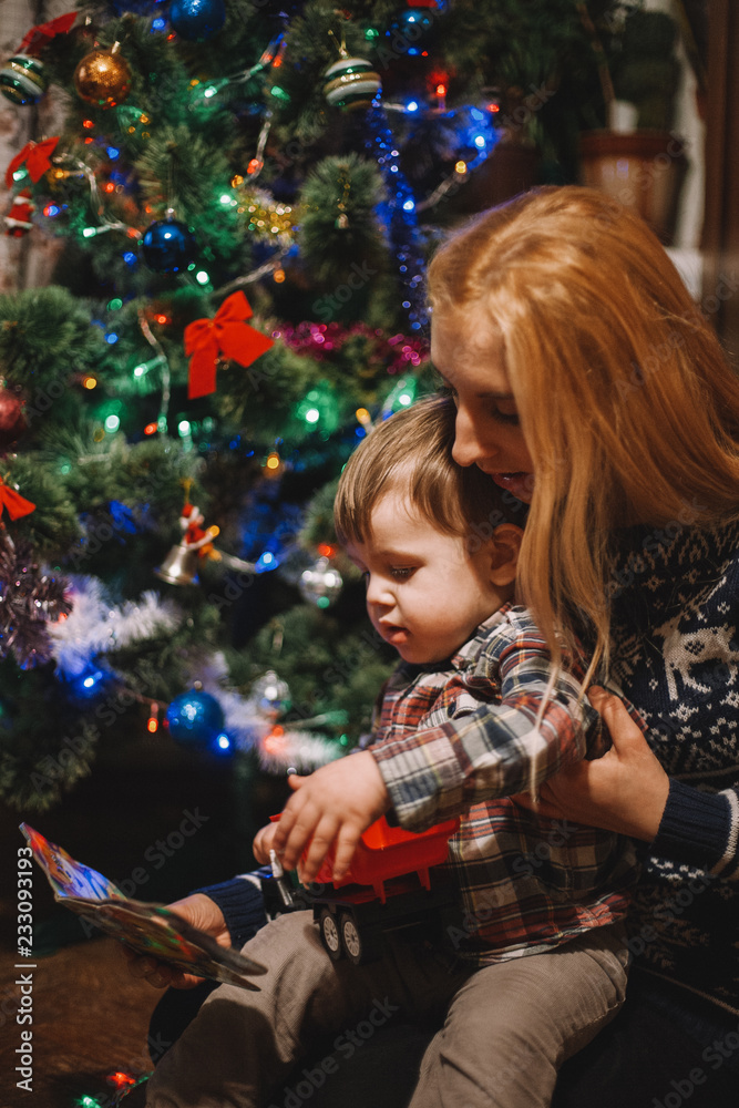 Mother and child sitting beside Christmas tree Mother and child sitting beside Christmas tree