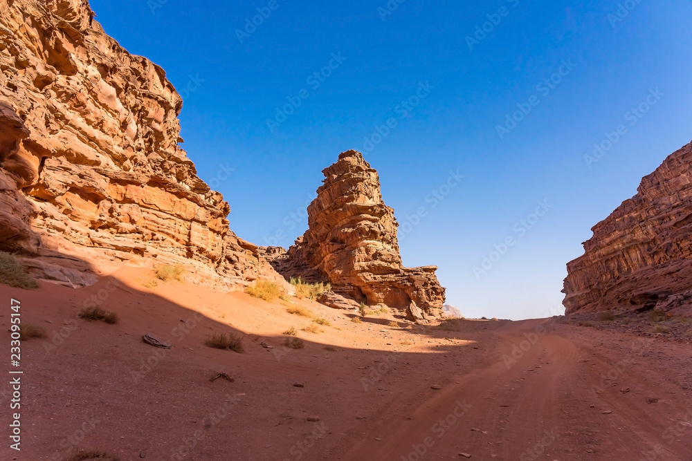 Red mountains of Wadi Rum desert in Jordan. Wadi Rum also known as The Valley of the Moon is a valley cut into the sandstone and granite rock in southern Jordan to the east of Aqaba Red mountains of Wadi Rum desert in Jordan. Wadi Rum also known as The Valley of the Moon is a valley cut into the sandstone and granite rock in southern Jordan to the east of Aqaba