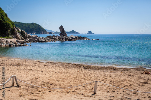 Beautyful Landscape with summer time Rock on sandy beach with blue water.