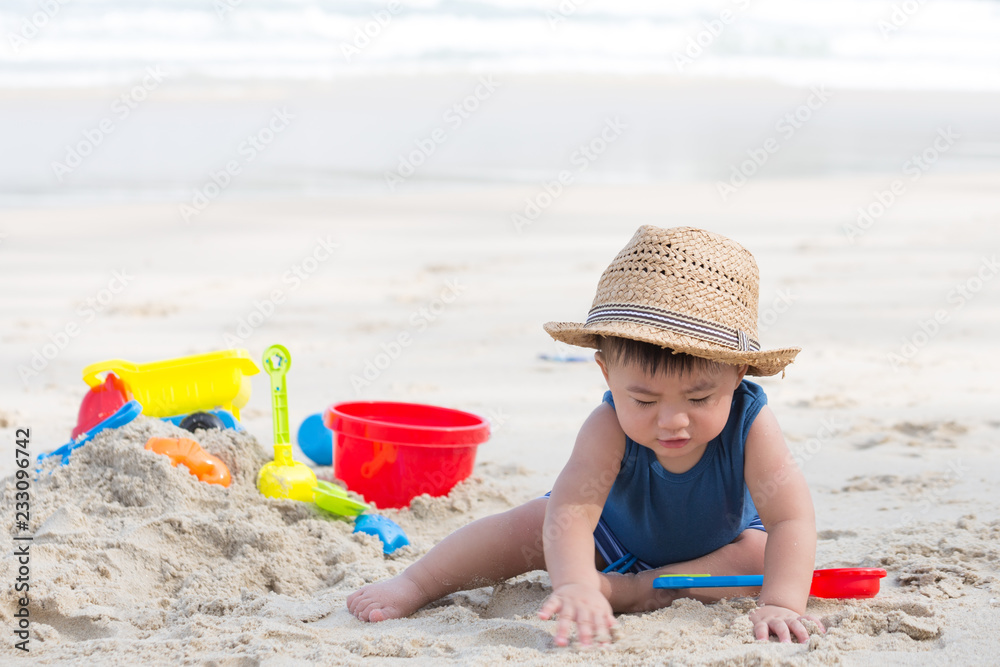 First year old boy play with sand, Taking baby to the beach concept First year old boy play with sand, Taking baby to the beach concept