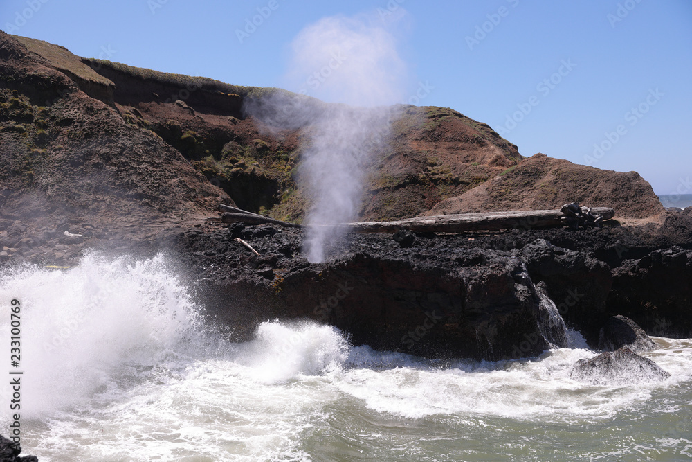 Spouting Horn natural phenomena at Cape Perpetua headland. Fountain of steam and salt water erupts from a hole in a basalt rock under the pressure of high tide, Oregon Coast