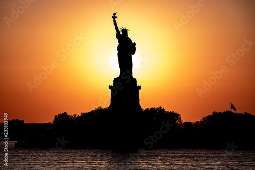 Scenic view of Statue of Liberty at a sunset. Sun behind the statue create beautiful silhouette.