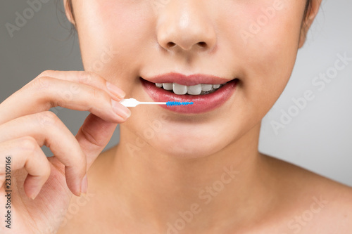 歯間ブラシを持つ女性