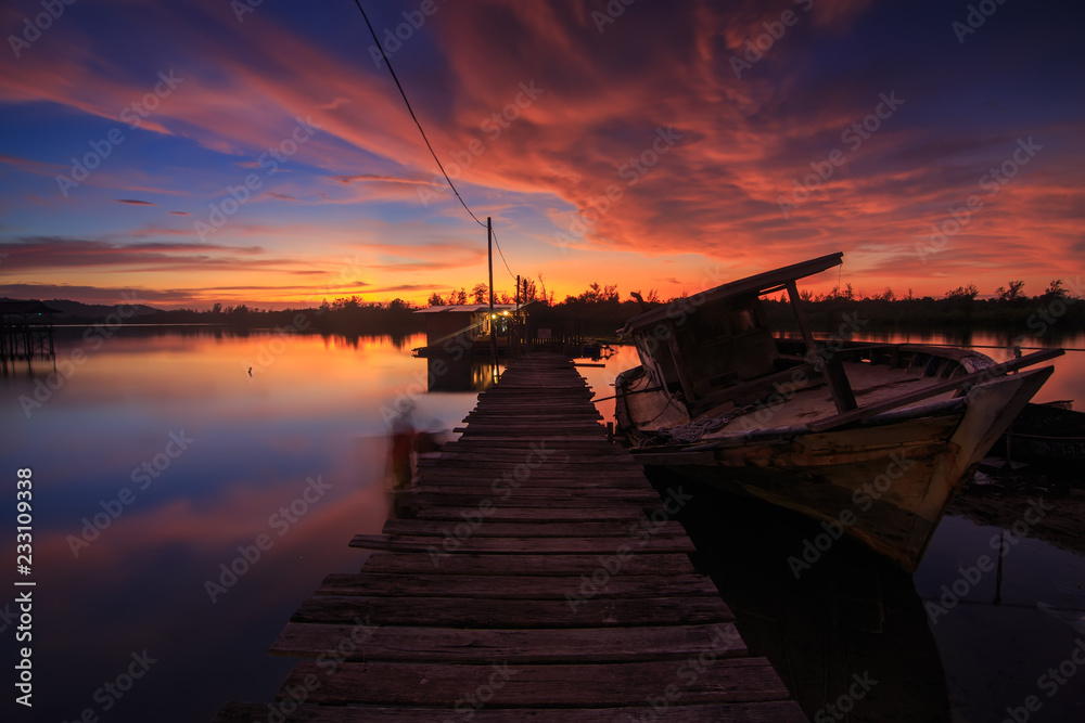 Abandon Old wreck on the shore , Borneo , Old fishing boat with the reflection on sunset moment