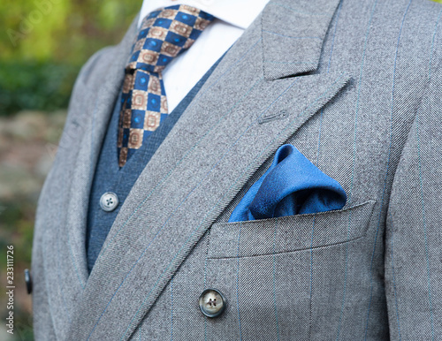 Unidentifiable torso of a man in an expensive suit with tie, vest and pocket square. photo