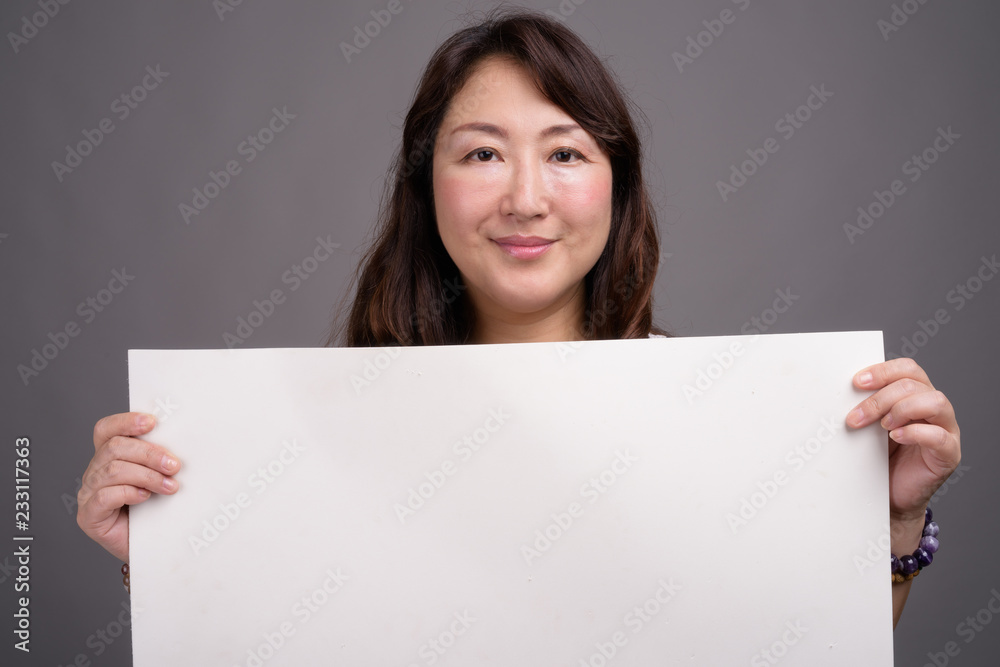 Mature beautiful Asian businesswoman showing copy space Mature beautiful Asian businesswoman showing copy space
