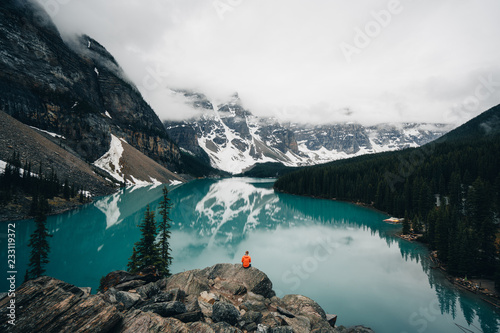 Person sitting on rock overlooking Moraine Lake, Canada