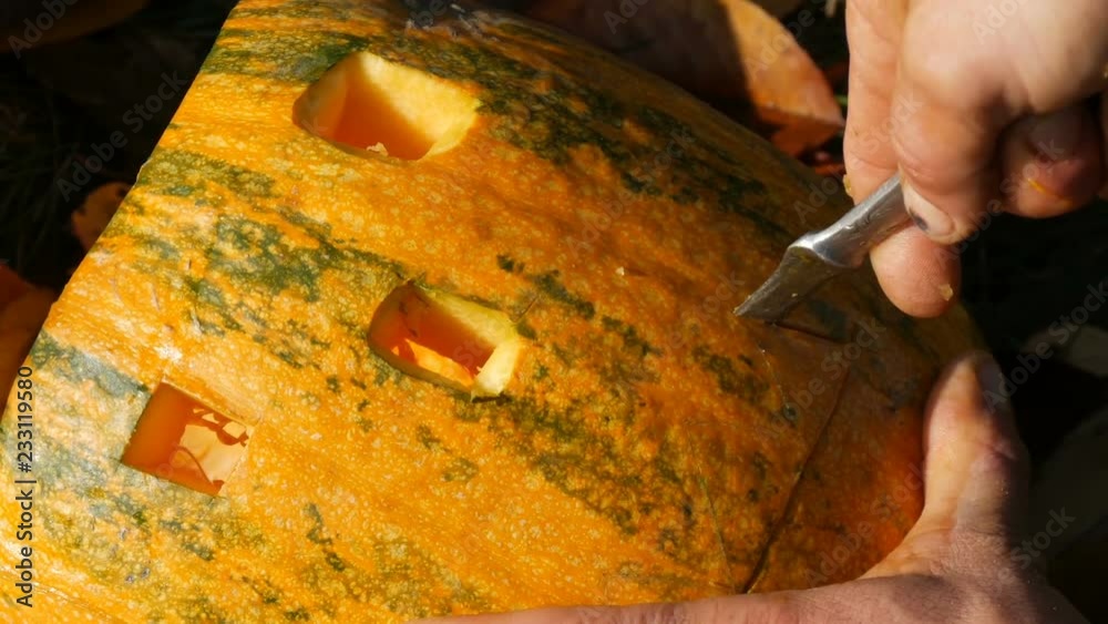 Man carves face for a halloween pumpkin. Preparing for the autumn holiday