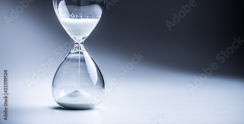 Modern hourglass in running time in studio lights photo