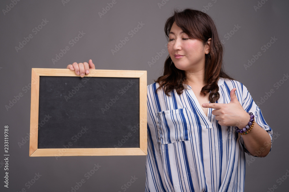 Asian businesswoman holding blackboard with copy space Asian businesswoman holding blackboard with copy space