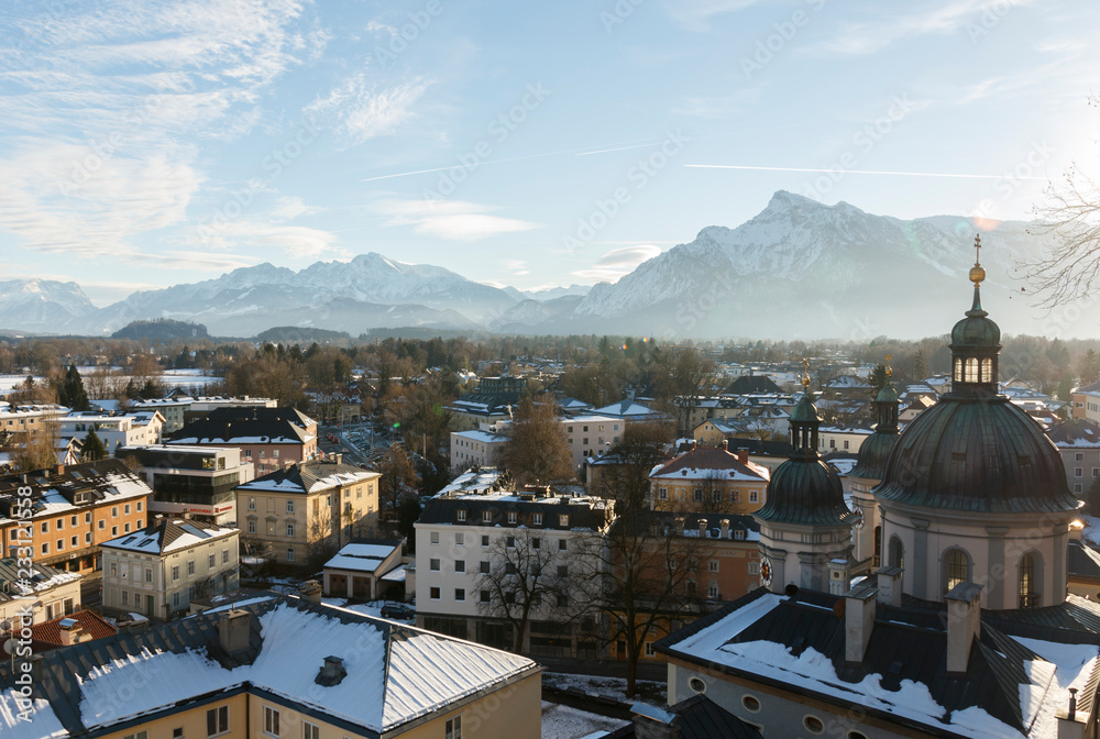 panoramic winter view of the historic center of Salzburg Austria surrounded by the Alps covered with snow in a foggy haze