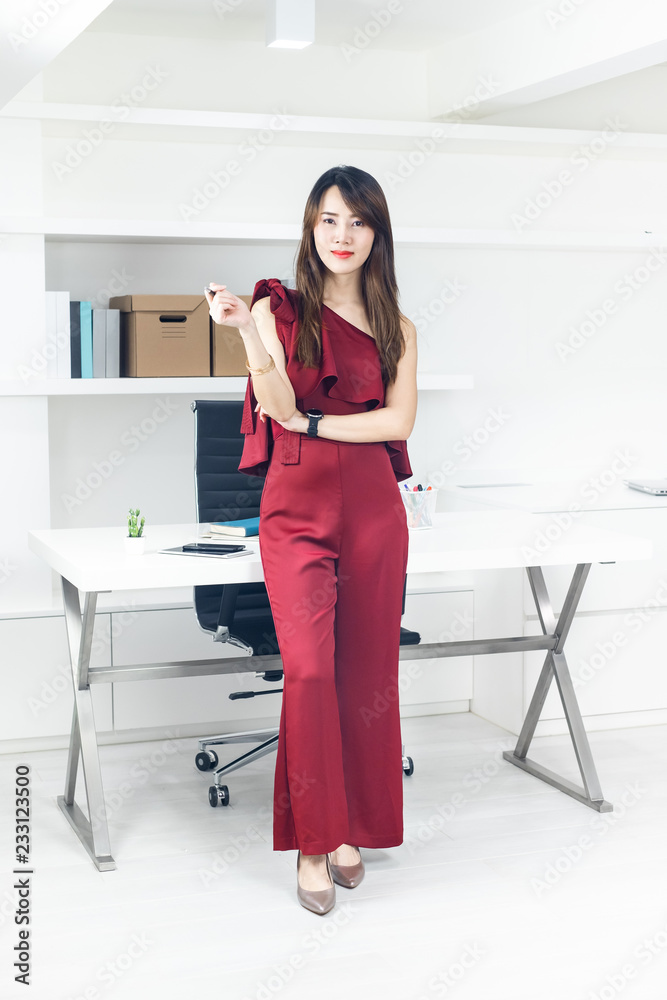 Portrait of beautiful smart Asian business woman standing in front of the table in workplace. Portrait of beautiful smart Asian business woman standing in front of the table in workplace.
