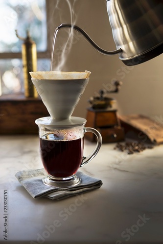 Hot water pouring through coffee filter into coffee cup