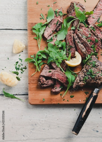 Strips of grilled pepper steak with rocket and parsley photo